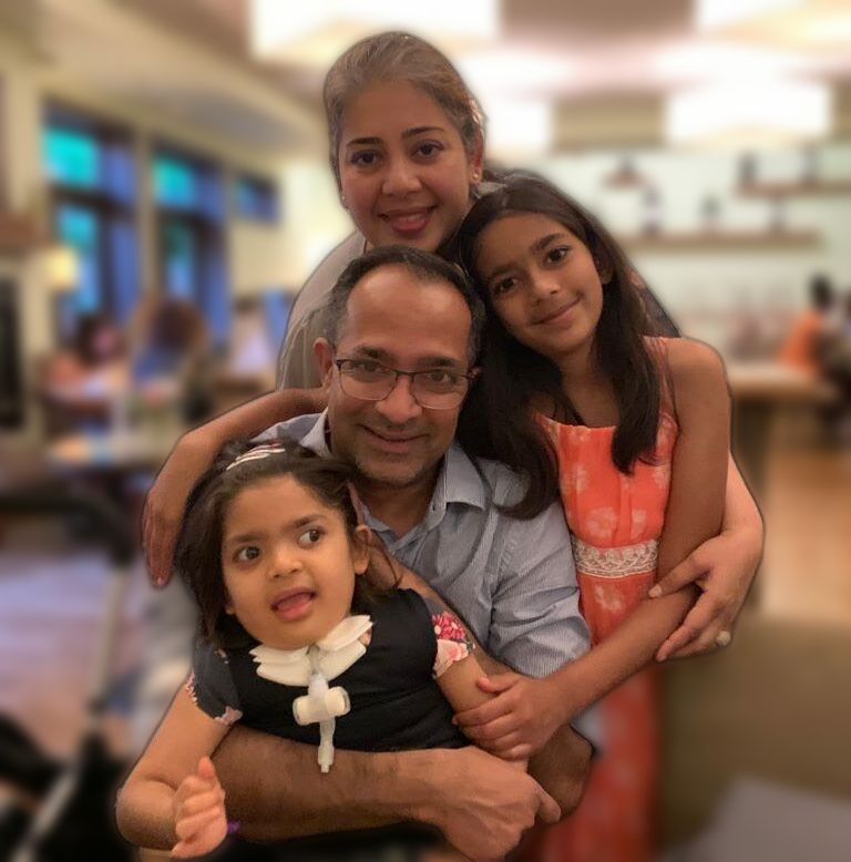 Support for families living with mitochondrial disease is our priority. Here, the Kshiti family poses for a photo holding each other and smiling.