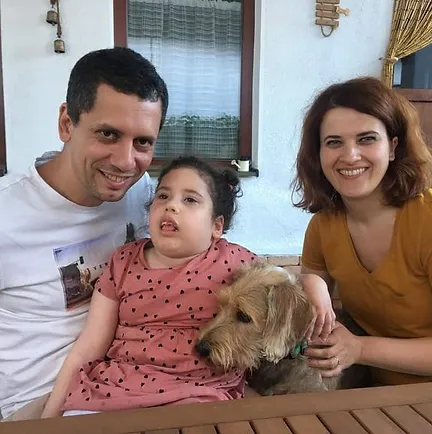 Family of three with their dog and child who is affected by Leigh Syndrome.