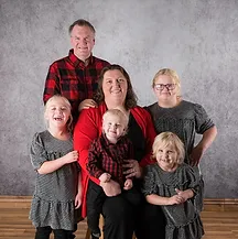 This photo features Anna Kerner Andersson, a member of the Cure Mito Advisory Board, along with her family and son who is affected by ECHS1D. They are pictured indoors in front of a gray backdrop. This image highlights the dedication of the advisors supporting Cure Mito's mission to find a cure for Leigh syndrome and other mitochondrial diseases.